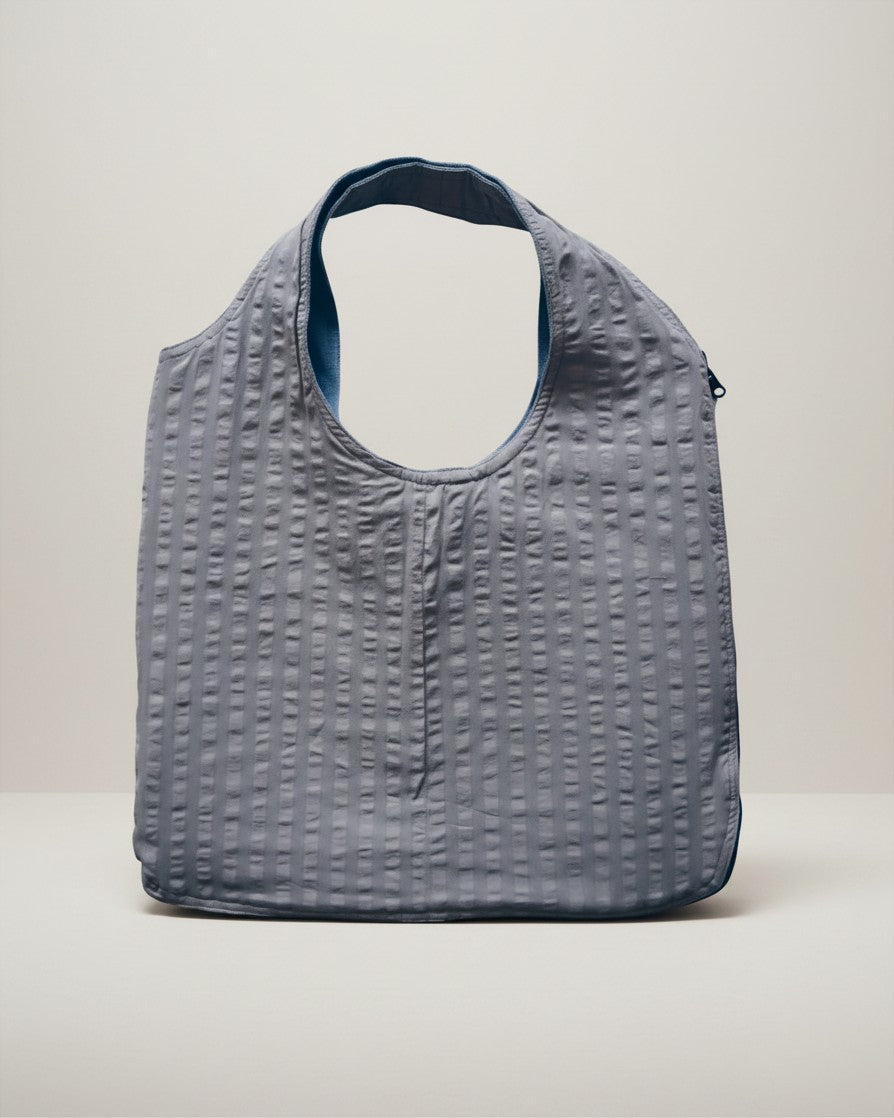 Hue Labs baby blue reversible vest bag made from upcycled materials with a textured finish and silver zipper.
