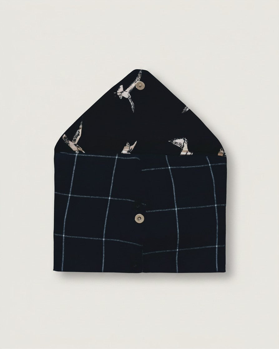 Hue Labs blue checkered envelope clutch made from upcycled textiles with a bird-patterned interior and magnetic snap.