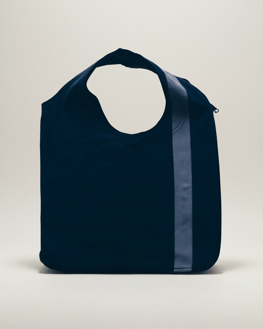 Hue Labs reversible blue vest bag made from upcycled materials with a vertical stripe and gun metal zipper detail