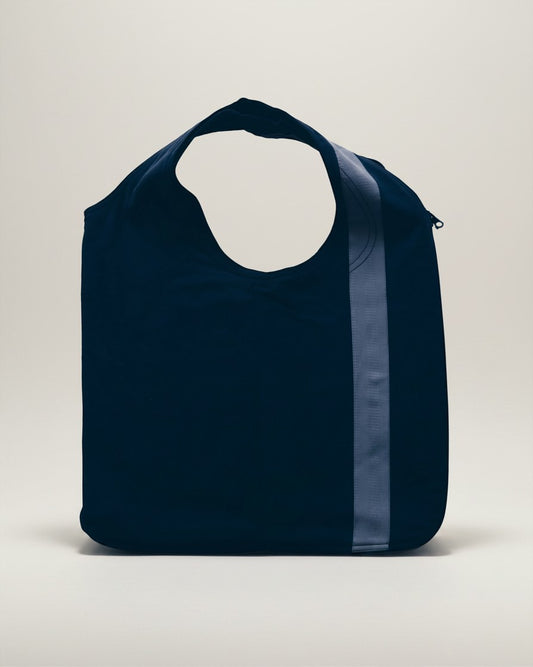 Hue Labs reversible blue vest bag made from upcycled materials with a vertical stripe and gun metal zipper detail