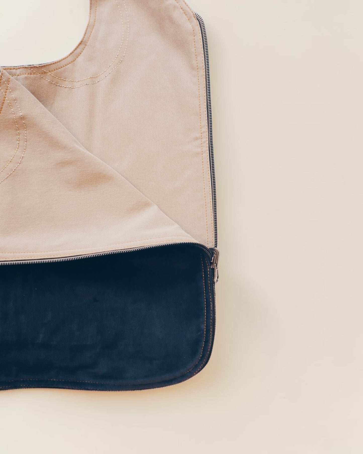 Hue Labs Everyday Essential tote bag in tan canvas with a dark blue interior lining and sturdy zipper closure.