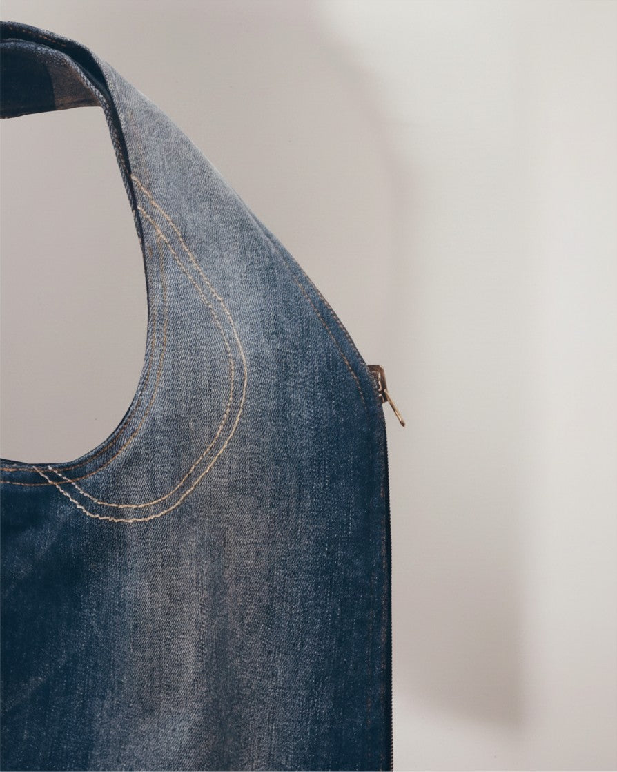 Hue Labs medium wash denim vest bag featuring durable stitching and a gun metal zipper, handcrafted from upcycled fabric