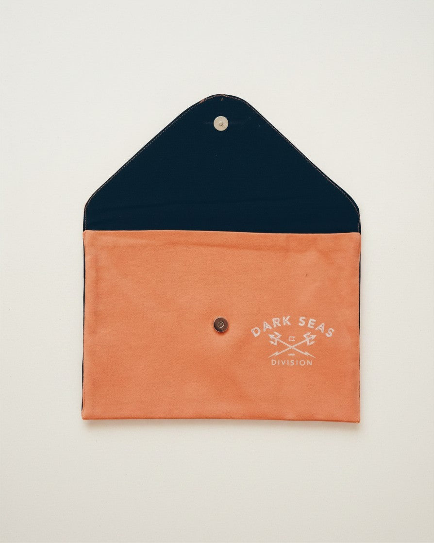 Hue Labs Peach Division envelope clutch made from upcycled textiles with a magnetic snap and Dark Seas logo print.