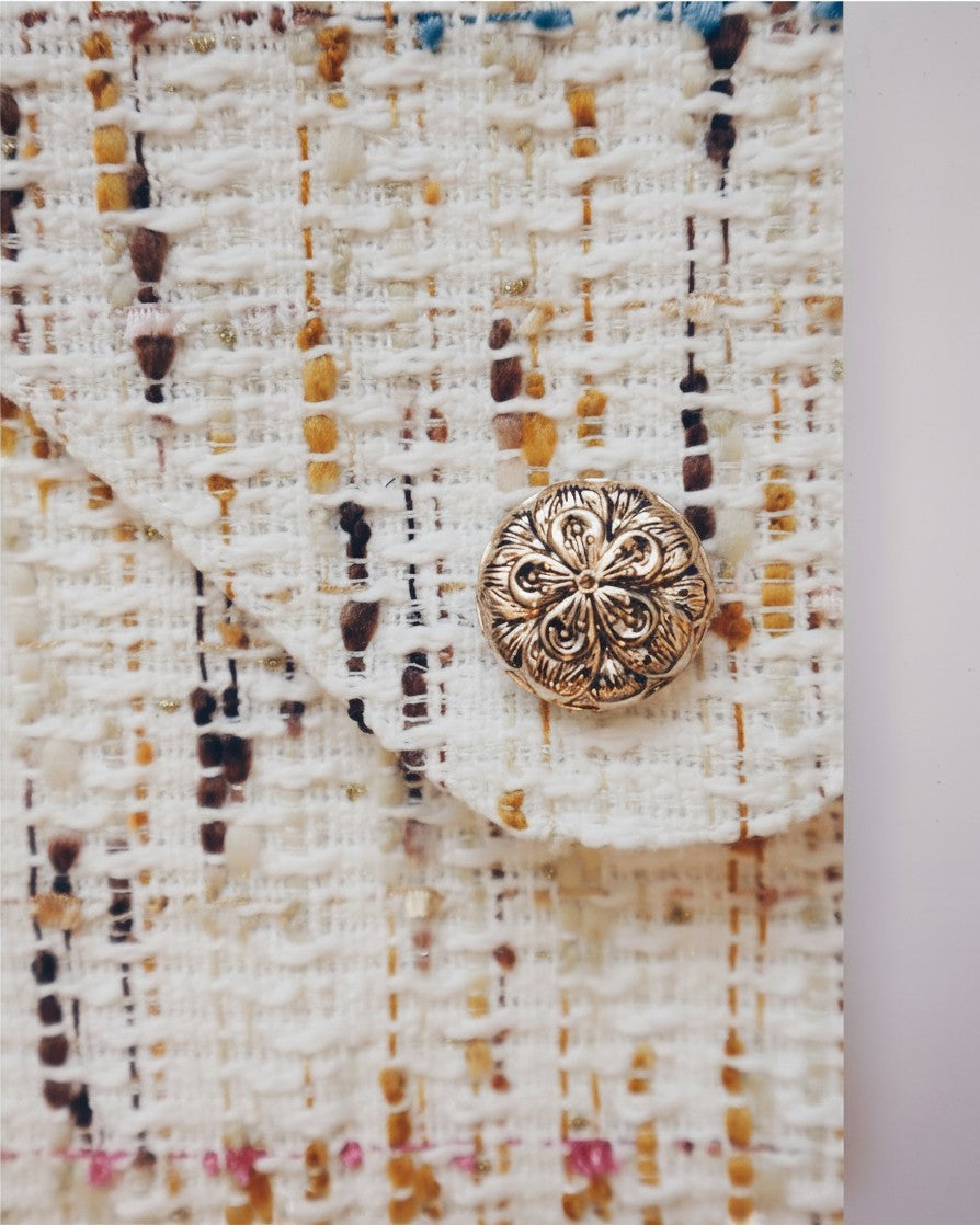 Hue Labs Popsicle envelope clutch made from textured upcycled cream fabric with a decorative gold floral snap button.