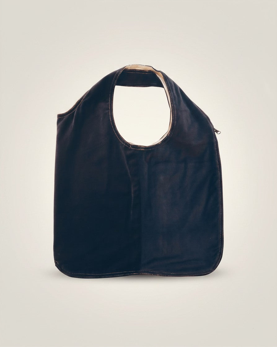 Hue Labs reversible white and dark grey upcycled vest bag with a gun metal zipper, shown as a shoulder tote.