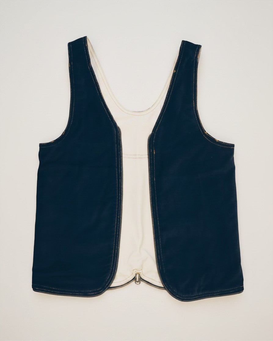Hue Labs reversible white and dark blue upcycled vest bag with a silver metal zipper, front view.