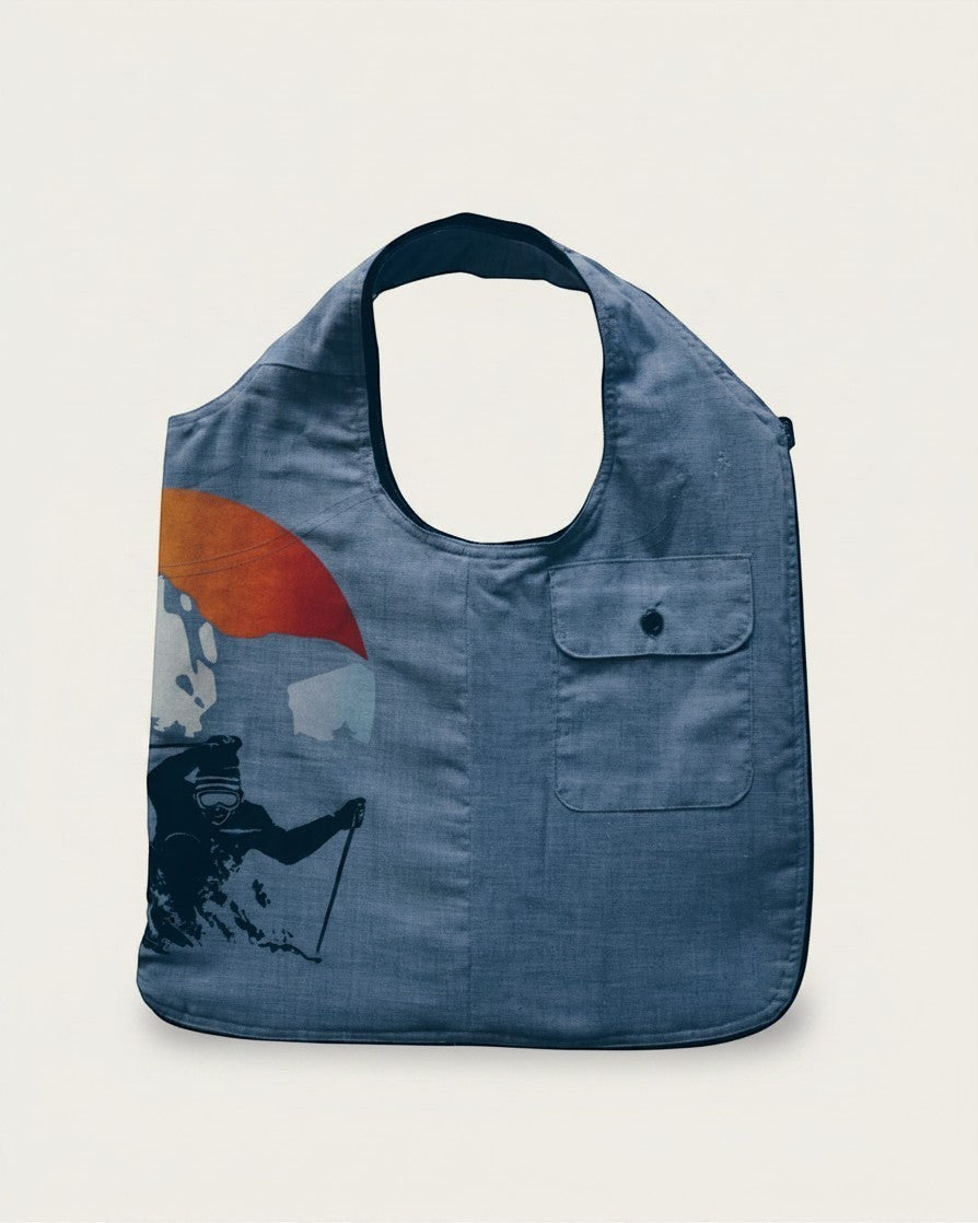 Hue Labs Sun Valley reversible vest bag in blue featuring a graphic print of a skier and a front pocket.