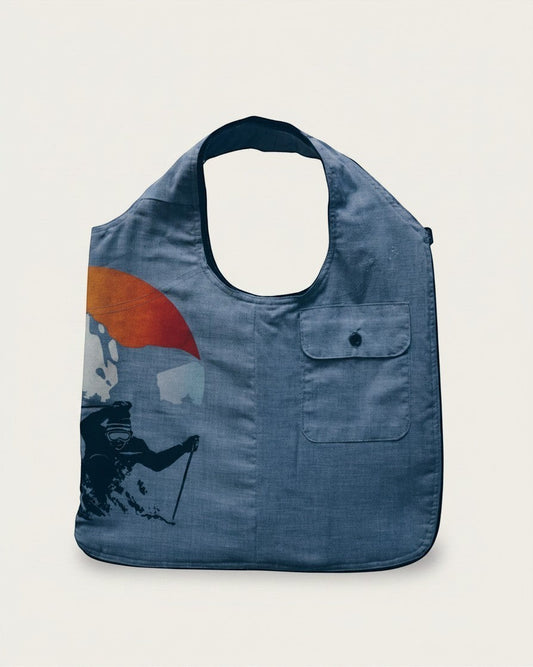 Hue Labs Sun Valley reversible vest bag in blue featuring a graphic print of a skier and a front pocket.
