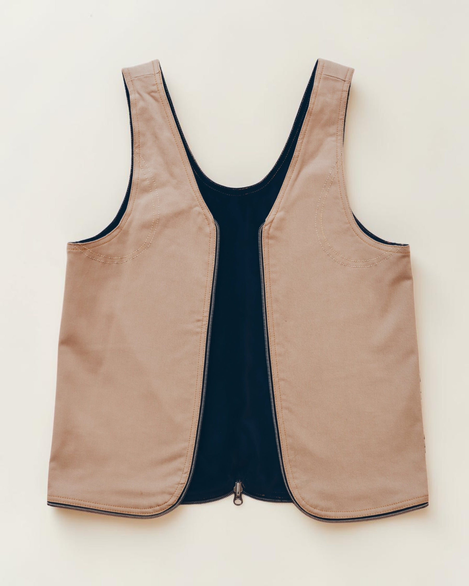 Hue Labs tan and black sleeveless vest with a front zipper closure and minimalist structured design.
