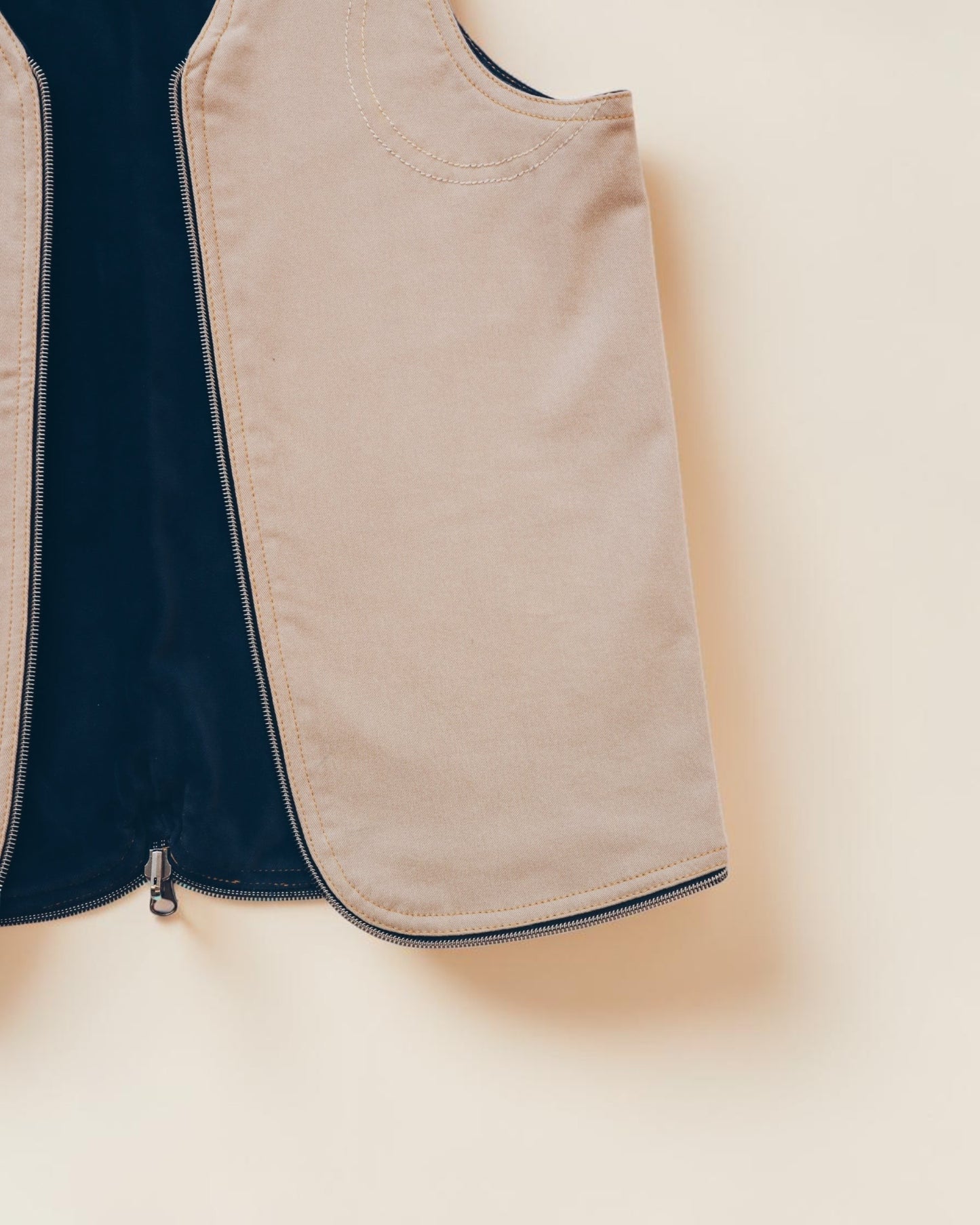 Hue Labs tan zip-up vest with dark navy interior lining and minimalist structured design.