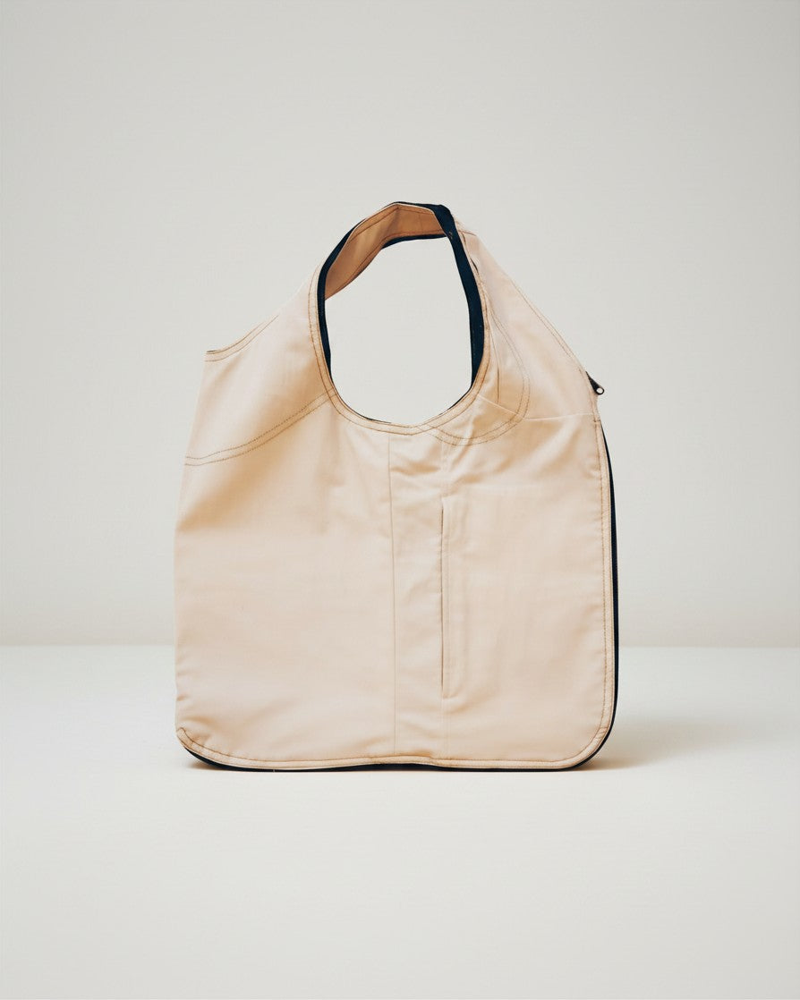 Hue Labs white upcycled vest bag with gun metal zipper, designed as a versatile reversible bag and wearable vest.
